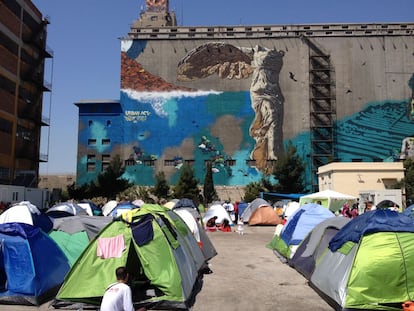 El campamento de refugiados del Pireo con un grafiti de la Victoria de Samotracia al fondo.