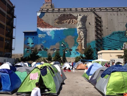 El campamento de refugiados del Pireo con un grafiti de la Victoria de Samotracia al fondo. 