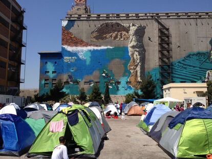 El campamento de refugiados del Pireo con un grafiti de la Victoria de Samotracia al fondo. 