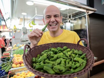 El mago, presentador y humorista Jandro, este lunes con una cesta de pimientos de Padrón en el Mercado Central de Valencia.
