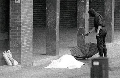 Un <i>ertzaina,</i> ante el cadáver del periodista José Luis López de la Calle, el 7 de mayo de 2000.