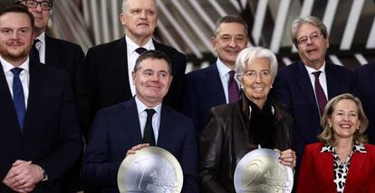 El presidente del Eurogrupo, Paschal Donohoe (sosteniendo una moneda de 1 euro), la presidenta del BCE, Christine Lagarde, y la vicepresidenta económica española Nadia Calviño, el lunes en Bruselas, con otros miembros del Eurogrupo.