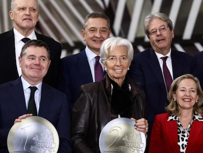 El presidente del Eurogrupo, Paschal Donohoe (sosteniendo una moneda de 1 euro), la presidenta del BCE, Christine Lagarde, y la vicepresidenta económica española Nadia Calviño, el lunes en Bruselas, con otros miembros del Eurogrupo.