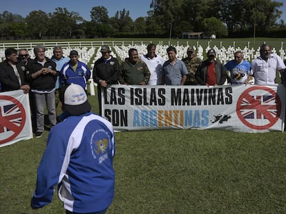 Veteranos de guerra de las Malvinas despliegan una pancarta frente a una réplica del cementerio de Darwin en Pilar.