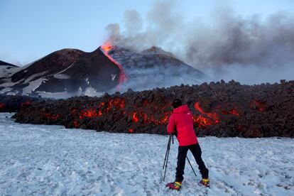 En la imagen, un fotógrafo capta con su cámara una imagen del volcán siciliano Etna, que ha entrado en erupción, cerca de la ciudad de Catania (Italia).