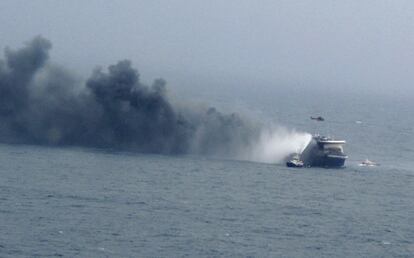 Vista panorámica del barco incendiado cubierto de humo. Se aprecia también uno de los helicópteros italianos que han ido rescatando de dos en dos a las más de 400 personas, entre pasajeros y tripulación, que permanecían a bordo del ferri cuando se declaró en incendio.