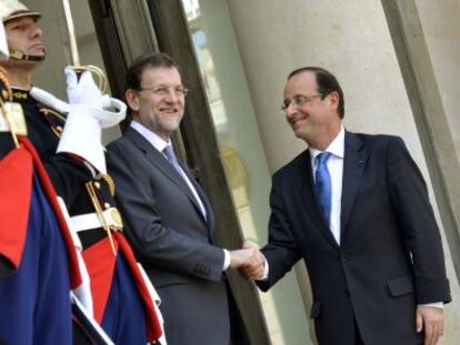 El presidente del Gobierno, Mariano Rajoy, saluda a François Hollande, en la puerta del Elíseo.