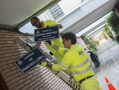 Dos operarios municipales cambian las placas de una de las calles. 
