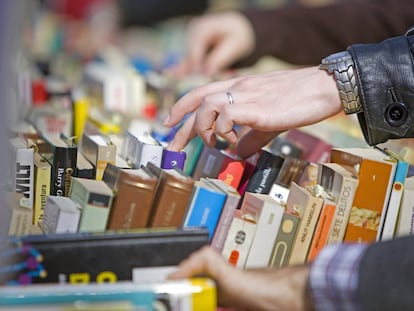 Varias personas escogen libros en una tienda de segunda mano.