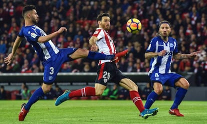 Aritz Aduriz, delantero del Athletic, disputa el balón a Duarte y Alexis, zagueros del Alavés.