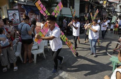 Manifestantes transportan una cruz de madera con notas de papel con deseos, preocupaciones y problemas de los pobres, el 16 de abril de 2019, en Manila (Filipinas).