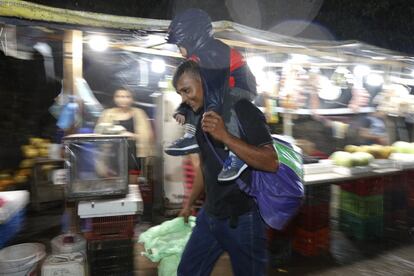 Un hombre lleva a su hijo sobre sus hombros bajo la lluvia durante el inicio de la segunda caravana de migrantes hondureños. 68% de la población hondureña vive en condiciones de pobreza, según el Instituto Nacional de Estadísticas (INE), y la violencia cobra un promedio de 11 homicidios diarios en el país, según el Ministerio de Seguridad.