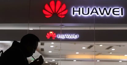 Un hombre pasa junto al escaparate de una tienda de Huawei en Pekín.