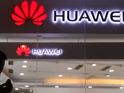 Un hombre pasa junto al escaparate de una tienda de Huawei en Pekín.