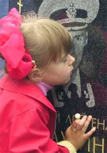Kristina, de cinco años, besa en San Petesburgo la foto de su padre muerto en el 'Kursk'.
