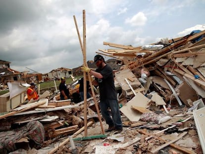 Vecinos de Forney, en Tejas, recogen los escombros de sus hogares tras el paso de los tornados.