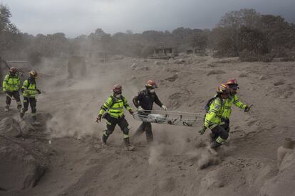 Un equipo de rescate corre alejandose de una nueva nube de ceniza expulsada por el Volcán de Fuego en El Rodeo (Guatemala), el 5 de junio de 2018.