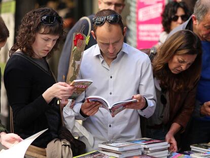 Ciudadanos en un tenderete de libros en la Rambla de Girona.