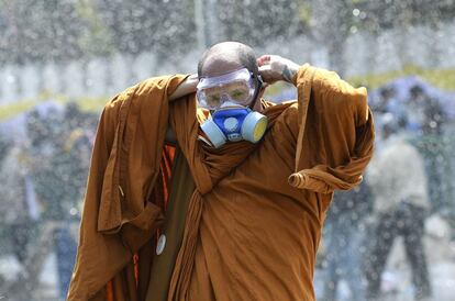 Bangkok (Tailandia), 2 de diciembre de 2013. Manifestaciones contra el gobierno en Tailandia. La oposición, encabezada por el Partido Democrático, volvió a salir a la calle para intentar derrocar a la primera ministra Yingluck Shinawatra y terminar con la influencia de su familia en la política tailandesa. En la imágen, un monje budista se pone una máscara de gas para protegerse de los gases lacrimógenos utilizados por la policía durante unos disturbios que acabaron con la muerte de dos personas.