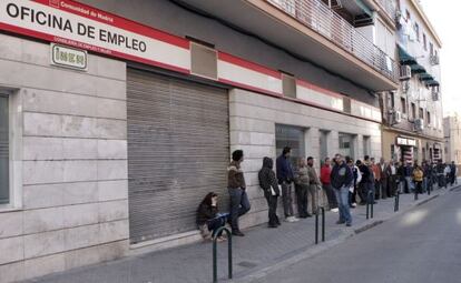 Decenas de personas esperan la apertura de una oficina de empleo en Madrid. 