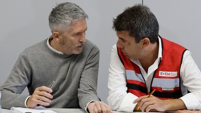 El presidente de la Generalitat, Carlos Mazón (d), conversa con el ministro del Interior, Fernando Grande-Marlaska en el Centro de Control de Emergencias, el viernes.
