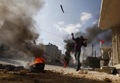 Un manifestante palestino utiliza una honda para lanzar piedras a los oficiales de seguridad israelíes cerca de Ramala.