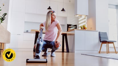 Una mujer con una fregona eléctrica en su casa.