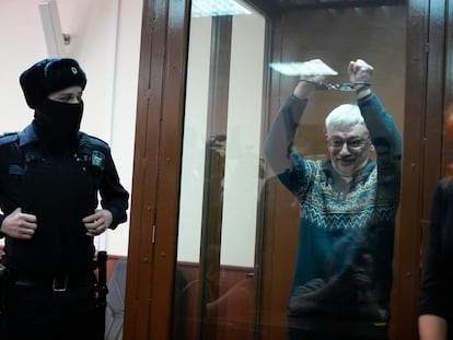 El activista ruso Oleg Orlov muestra las esposas mientras comparece ante un tribunal de Moscú, este martes.