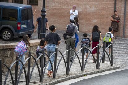 Unos padres caminan junto a sus hijos a la salida del colegio.