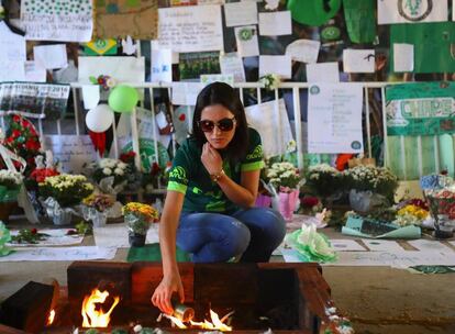 Torcedora da Chapecoense acende uma vela para as vítimas da tragédia, no estádio do time.