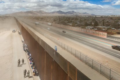 Migrantes se agrupan junto a la valla fronteriza mientras esperan a ser procesados tras cruzar el río Grande hacia Estados Unidos, en El Paso (Texas) en marzo de 2024.