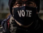 Un votante con una máscara en la que se puede leer "Vota" hace cola en un centro de votación en el Parque Nacional, en Washington, DC. Las de este martes serán unas elecciones complejas. El alto número de votos recibidos antes de la jornada electoral y las leyes de cada uno de los 50 Estados hacen impredecible definir el desarrollo de la noche.