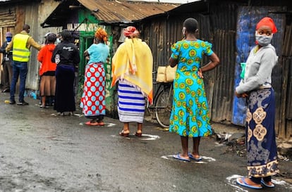 Varias residentes de Mathare hacen cola para recoger comida en tiendas del barrio.