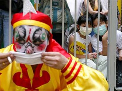 Un payaso desfila por las calles de Hong Kong con motivo de la fiesta de la reina del mar.