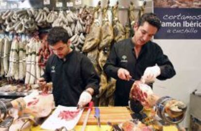 Dos trabajadores cortando jam&oacute;n en Viandas de Salamanca (Madrid)