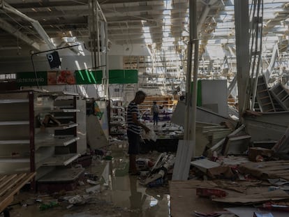 A man searches for food inside an Acapulco supermarket that was looted after the hurricane, on October 27.