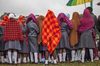 Las mujeres jóvenes se reúnen bajo la lluvia, en la Universidad de Nairobi, antes de una misa al aire libre pronunciado por el Papa.
