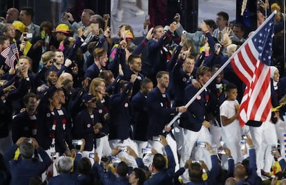 Michael Phelps de los Estados Unidos porta la bandera al frente de su delegación.