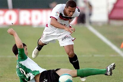 Adriano regatea al bético Melli durante el <i>derby</i> sevillano de ayer en el Sánchez Pizjuán.