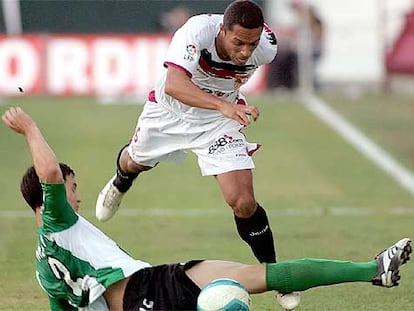 Adriano regatea al bético Melli durante el <i>derby</i> sevillano de ayer en el Sánchez Pizjuán.