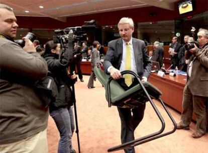 El ministro sueco de Exteriores, Carl Bildt, coloca una silla antes de iniciarse la reunión con sus homólogos europeos ayer en Bruselas.