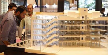 Visitantes del Salón Inmobiliario de Madrid observan una de las maquetas de viviendas expuesta en la feria.