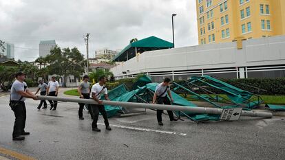 Bomberos de Tampa retiran un poste de la calle después de que grandes toldos de un edificio se desprendieran por los fuertes vientos. 