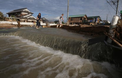 En el sur de Japón, a principios de julio, casi cinco millones de ciudadanos recibieron la orden de evacuar sus hogares debido a las fuertes lluvias. Al menos 75 personas fallecieron. En la imagen, varios residentes cruzan una zona inundada en Kurashiki, en la prefectura de Okayama, el 9 de julio de 2018.
