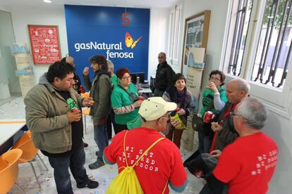 Membres de l'Aliança contra la Pobresa Energètica entren a una oficina de Gas Natural.