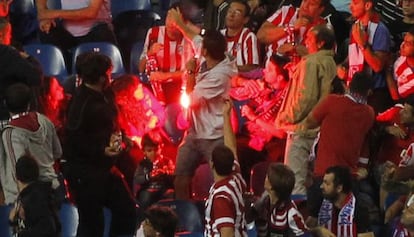 Hinchas del Benfica celebran el empata arrojando bengalas a la grada.