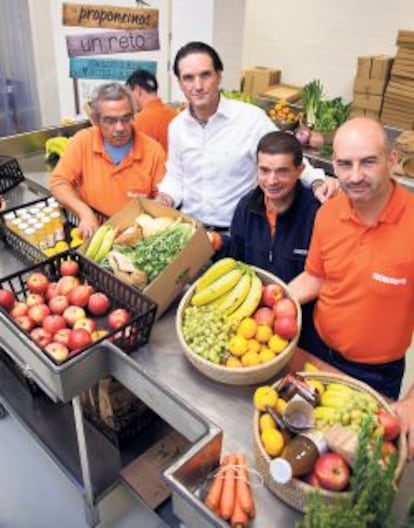 Eduardo Petrossi, consejero delegado de Mahou-San Miguel, posa junto a las personas que preparan las cestas de frutas y verduras que cultivan en la Fundación Juan XXIII, donde es voluntario.