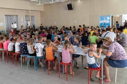 Los niños acogidos en diferentes orfanatos de la región de Donetsk almuerzan en Zolotaya Kosa, un asentamiento en el Mar de Azov, en el suroeste de Rusia, el viernes 8 de julio de 2022.
La infancia de la Federación Rusa no se libra de las garras de la pobreza. Esta representa casi las tres cuartas partes del aumento total del número de niños viviendo en esta situación debido a la guerra en Ucrania y a la crisis del coste de la vida en la región. Ahora hay 2,8 millones de menores de edad más viviendo en hogares bajo el umbral de la pobreza. En Ucrania hay ahora medio millón más de niños viviendo en esta situación, el segundo mayor aumento, seguido de Rumanía, con 110.000 niños más.