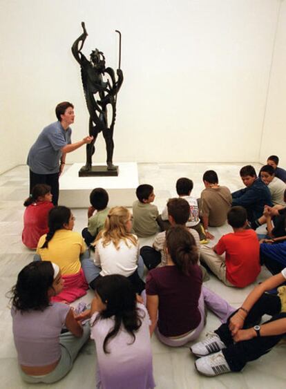 Niños atienden a las explicaciones sobre la escultura ?El Profeta' de Garllallo, Museo Centro de Arte Reina Sofía, Madrid