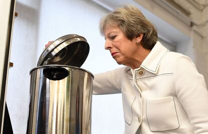 Theresa May observa el contenido de un robot de cocina, durante una visita a la sede de Vauxhall, en Londres, el 15 de octubre de 2018.  